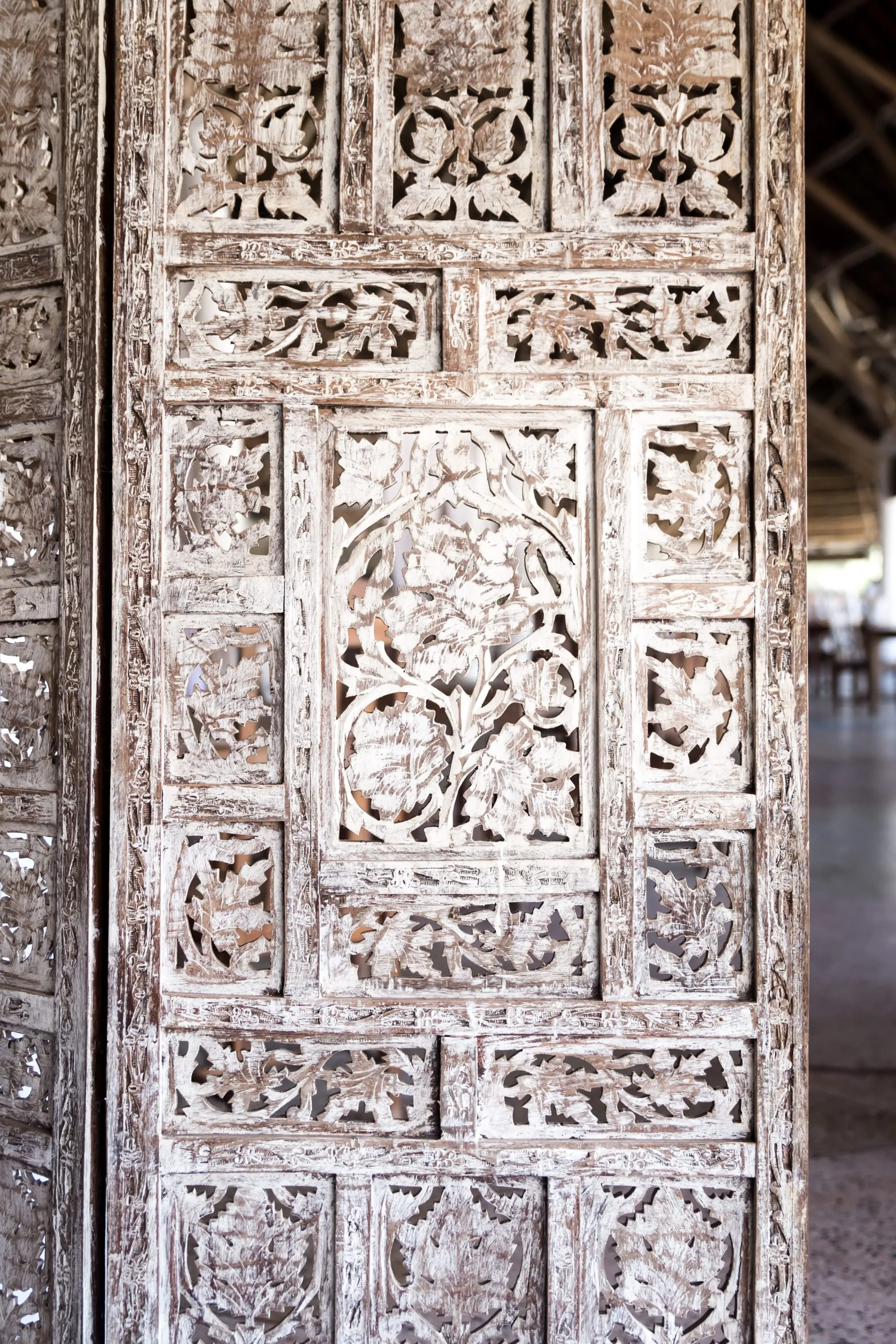 A whitewashed wooden door carved with panels of leaves and flowers, Zanzibar